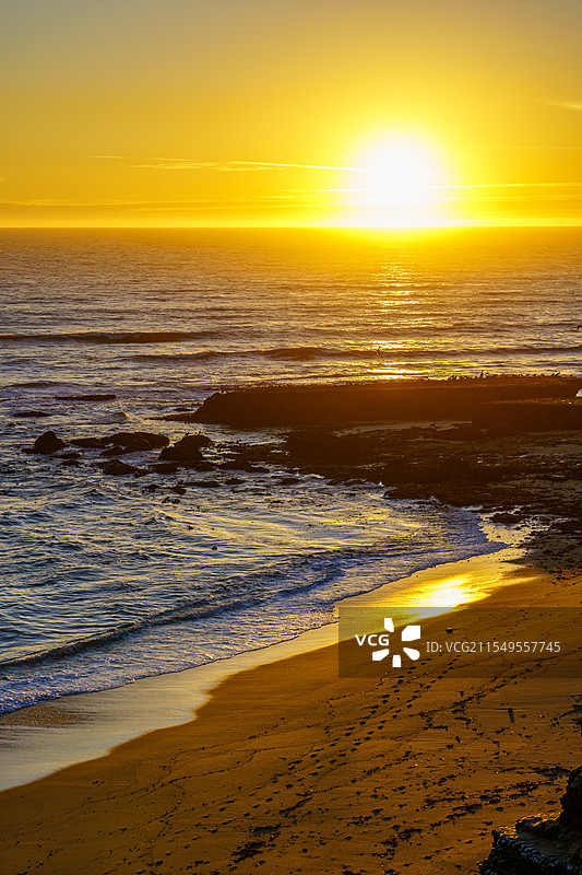 夕阳下的海滩和海边悬崖图片素材