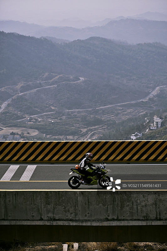 湖北将军山上飞驰的摩托车和远景的山峦图片素材