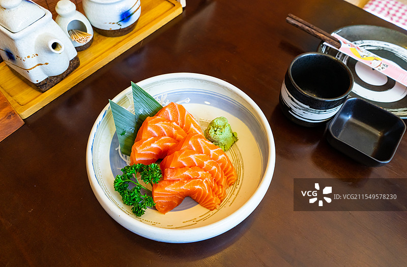 中国日料餐馆拍摄主题，餐馆的餐桌上一份做好的三文鱼金枪鱼和绿色的芥末辣根，室内无人图像摄影图片素材