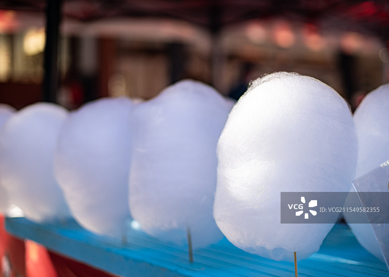 中国饮食产业拍摄主题庙会货摊零售展示,货摊上成一排的白色巨大的棉花糖，白昼户外无人图像摄影图片素材