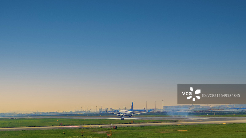 飞机降落在晴朗的蓝天下图片素材