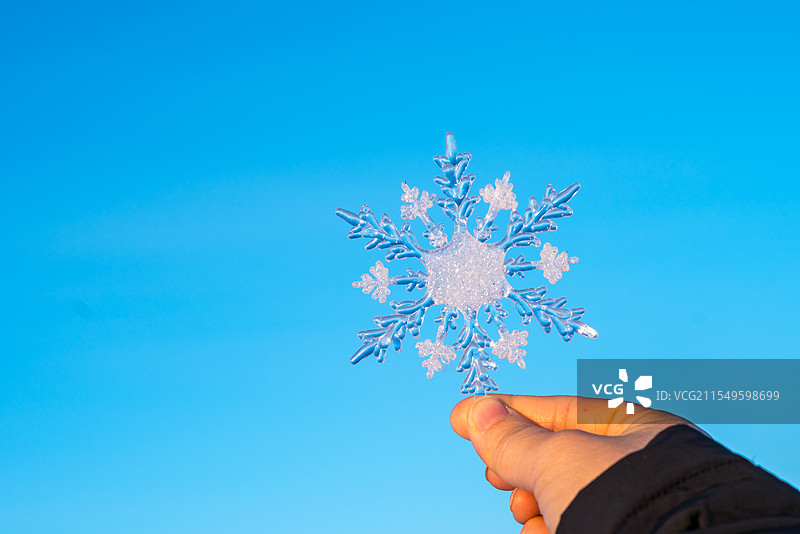 冬天天空下拿着美丽的雪花图片素材