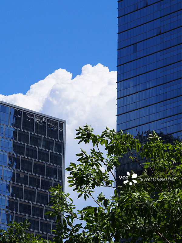 藏在高楼后的超大棉花糖云朵图片素材