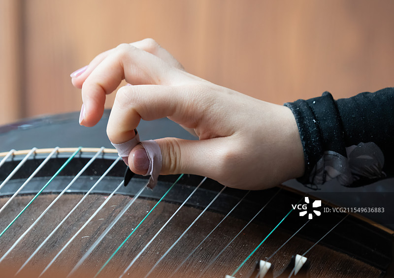 音乐家，弹奏古琴的手部特写图片素材