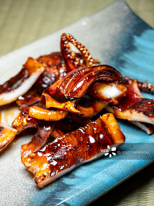 陶瓷盘上切开的烤鱿鱼图片素材