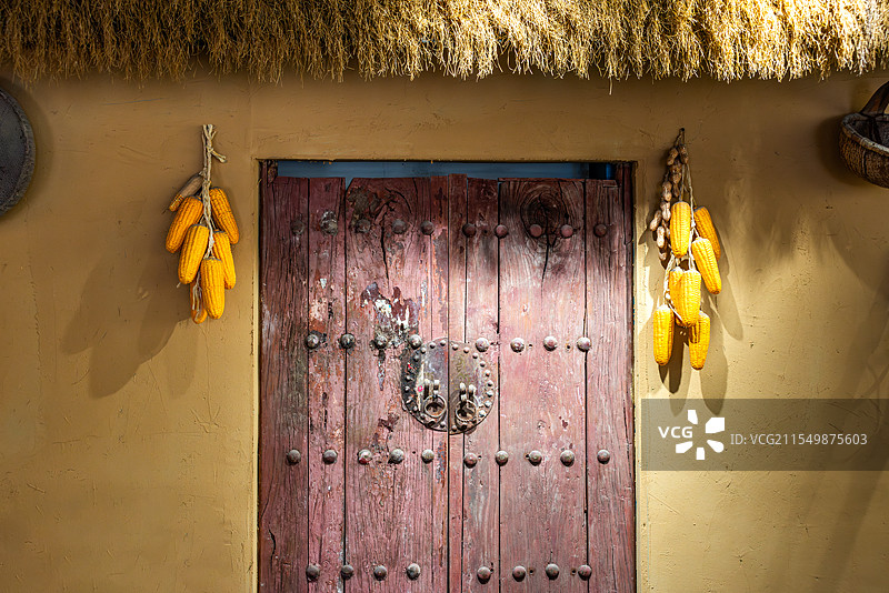 中国农村木门两侧挂着两串玉米图片素材