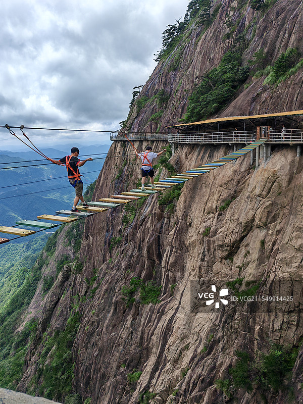 在多云的天空中走吊桥的人图片素材