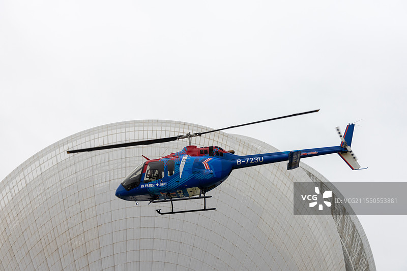 直升飞机在晴空中飞行的低角度视图图片素材