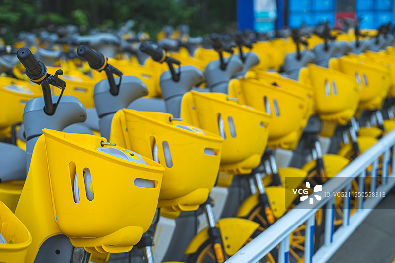 中国共享电动车拍摄主题，自行车停车场里，一排黄色的共享摩托车特写，户外白昼无人图像摄影图片素材