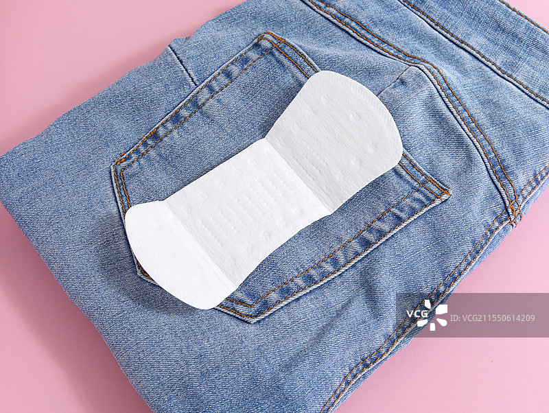 粉色背景上的裤子和女性月经用品卫生巾卫生棉图片素材