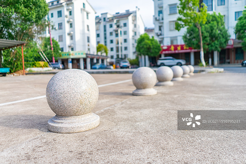 中国城市市政建筑材料拍摄主题，斑马线道路出入库的一排圆形石墩子，户外白昼无人图像摄影图片素材