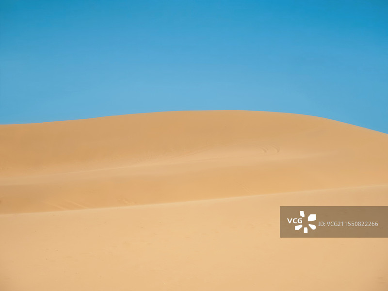 蓝天映衬下的沙漠景观图片素材