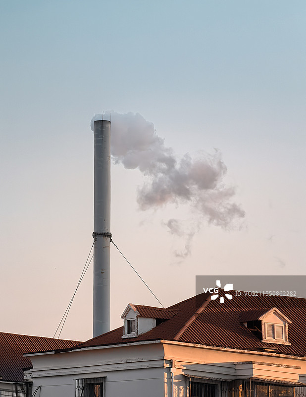 夕阳下的红房顶和冒着烟的烟囱图片素材