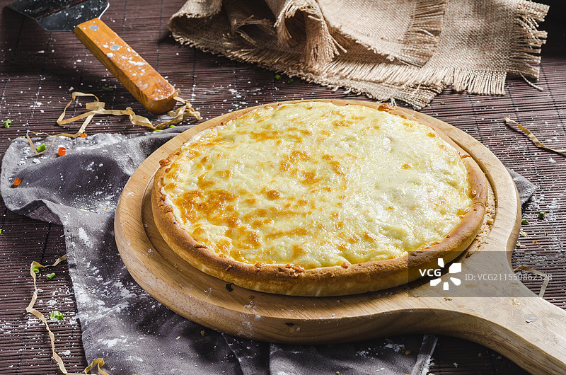 不同馅料的披萨，置于木制披萨板上。图片素材