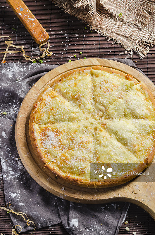 不同馅料的披萨，置于木制披萨板上。图片素材