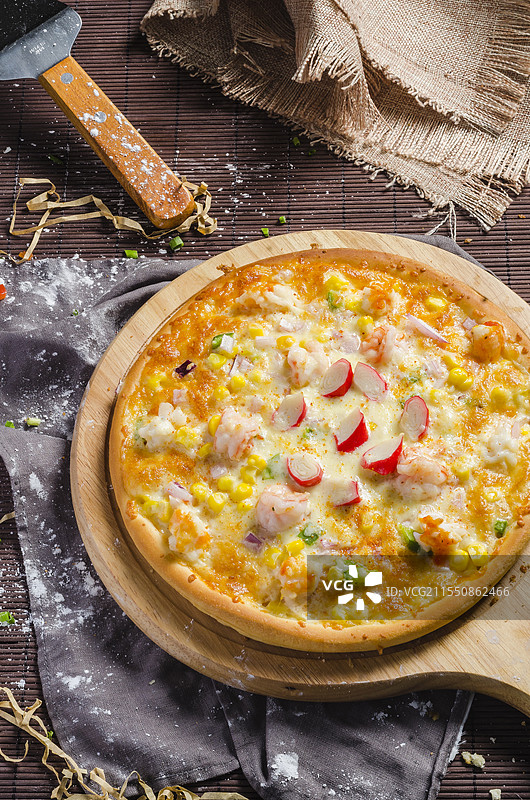 不同馅料的披萨，置于木制披萨板上。图片素材