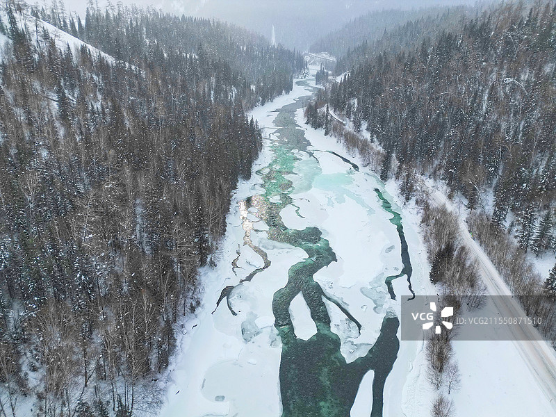 喀纳斯冰雪中的翠绿河流图片素材