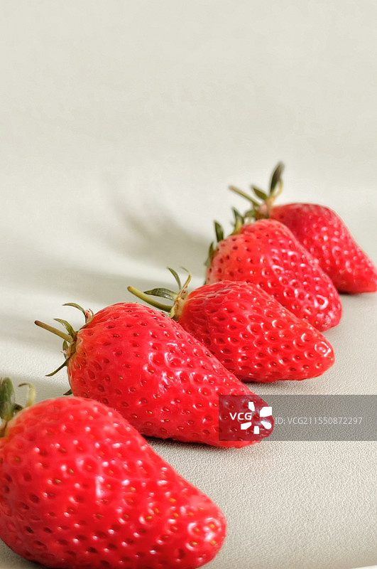纯色背景五颗草莓斜摆桌面特写图片素材