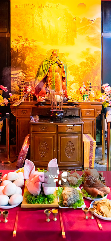 中国传统农业文化祭祀拍摄主题，桌子上的财神爷酒盅和猪头、馒头、鱼、丸子、水果贡品，室内无人图像摄影图片素材