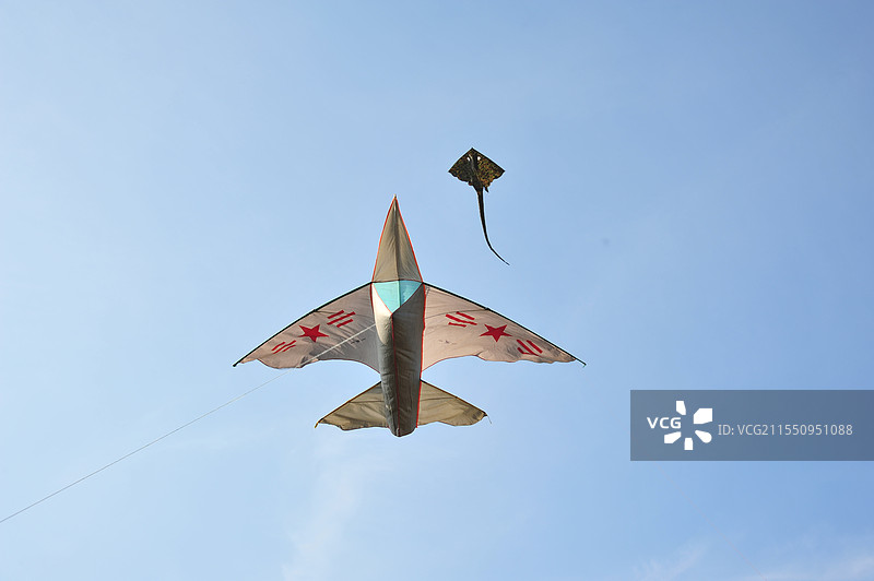 风筝在蓝天下飞翔的低视角图片素材