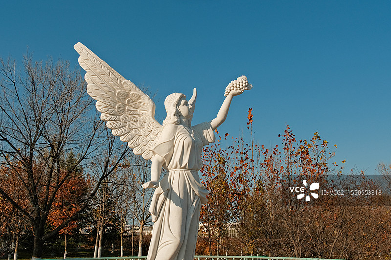生有双翼 手举葡萄的女性天使塑像图片素材
