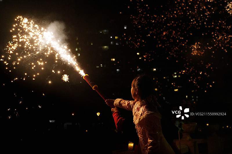 夜里烟花放烟花的小女孩图片素材