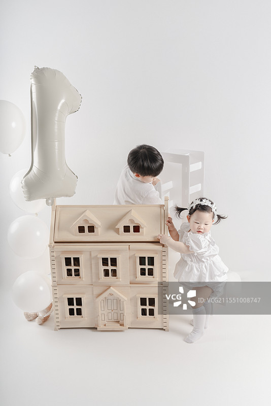 五岁男孩与一周岁女孩布置装饰生日聚会场地图片素材