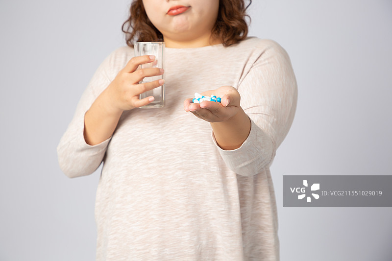正在吃药的亚洲肥胖女孩图片素材