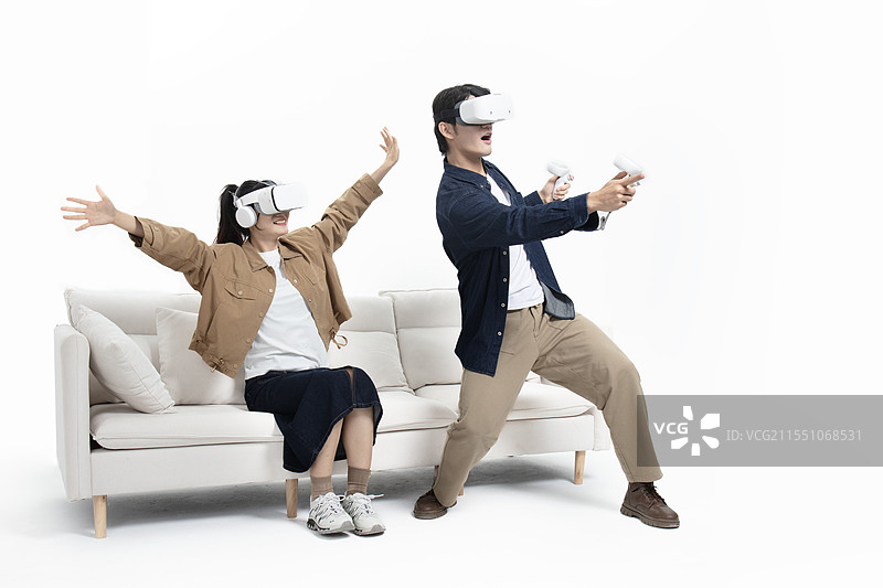 坐在沙发上玩VR游戏的年轻情侣图片素材