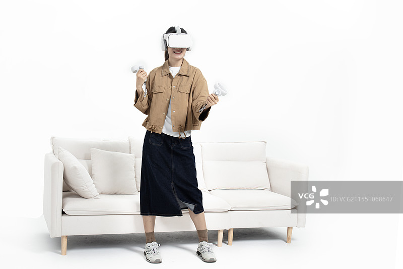 坐在沙发上玩VR游戏的年轻女人图片素材