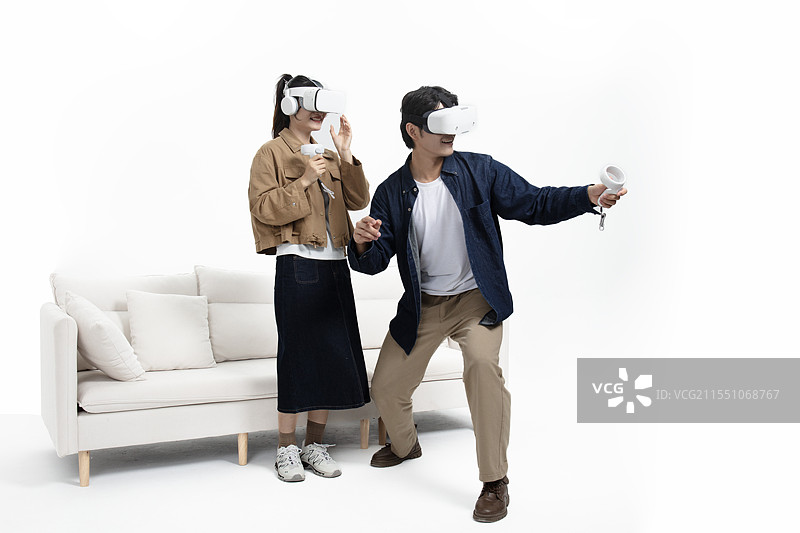 站在沙发前玩VR游戏的年轻情侣图片素材