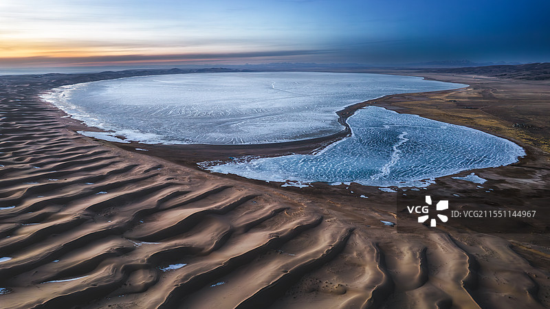 夕阳下无人沙漠旁的冰封湖面图片素材