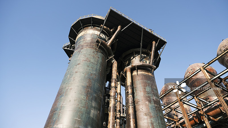 蓝天下烟囱的低角度视图图片素材