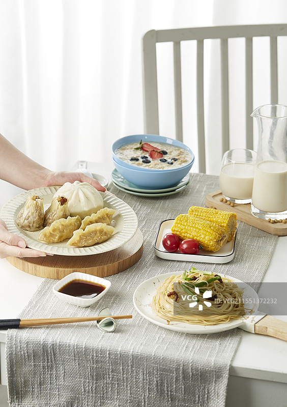 餐桌上丰盛的早餐 燕麦包子面条烧卖图片素材