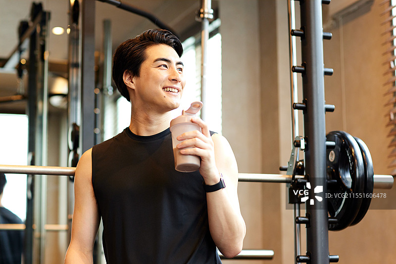 微笑的日本男子手持蛋白质奶昔图片素材