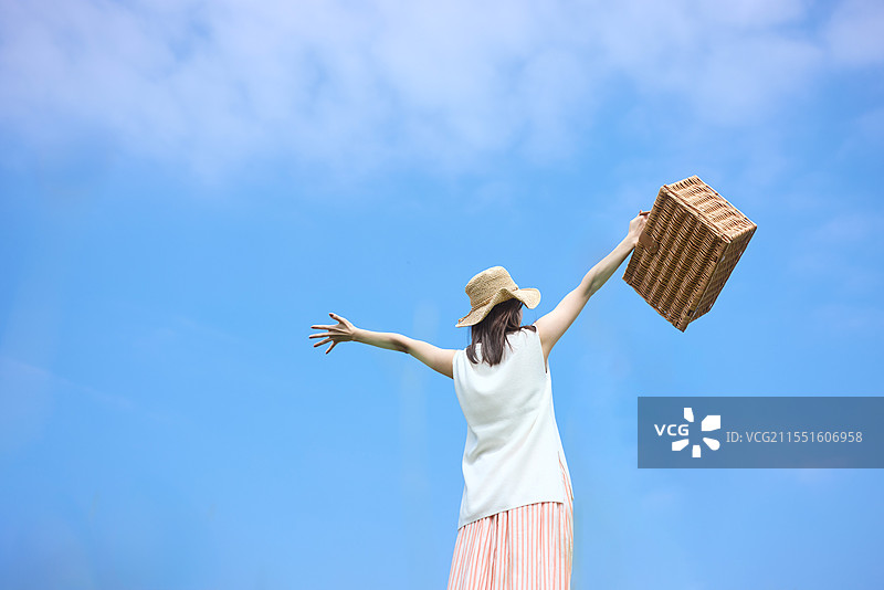 日本女性在蓝天中手持一个木盒子图片素材