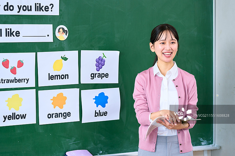在黑板前的日本老师与她的学生们图片素材