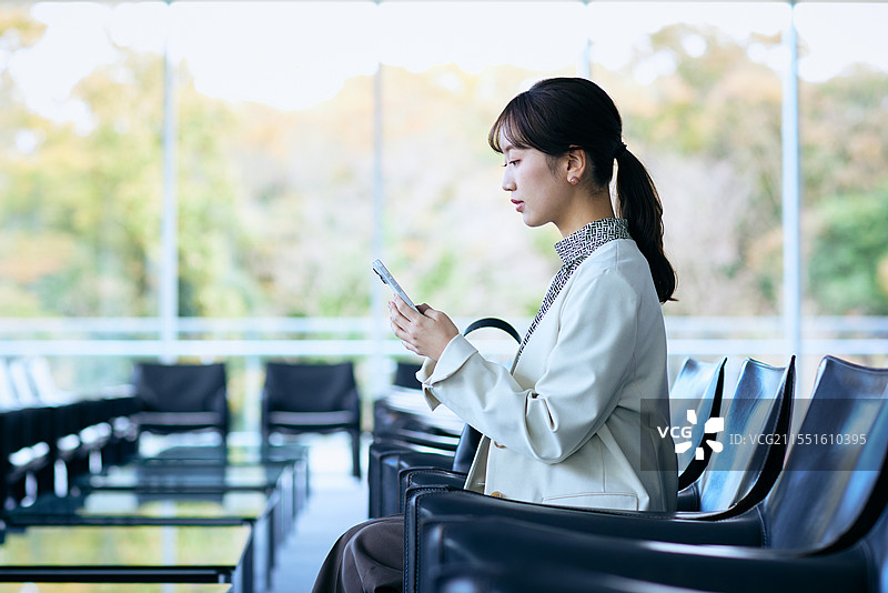 在机场使用智能手机的日本女性图片素材