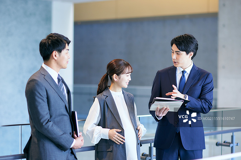 三位商务人士站在办公大楼内图片素材