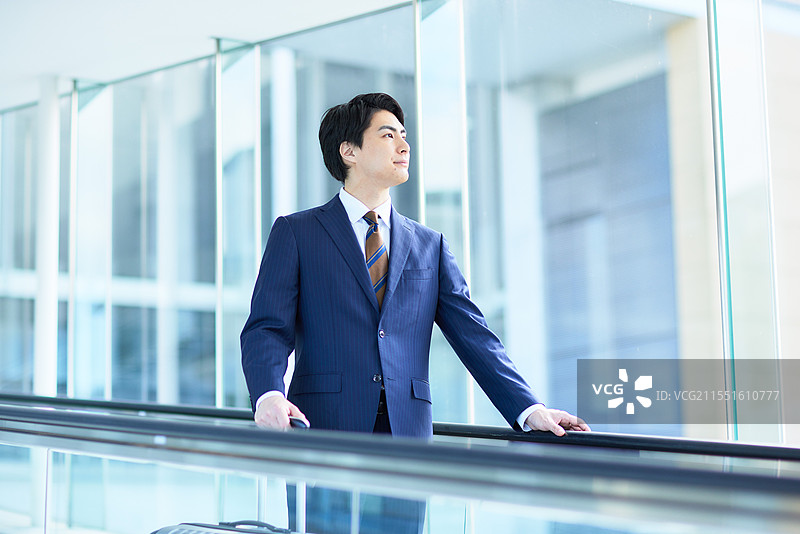 日本商人站在自动扶梯上图片素材