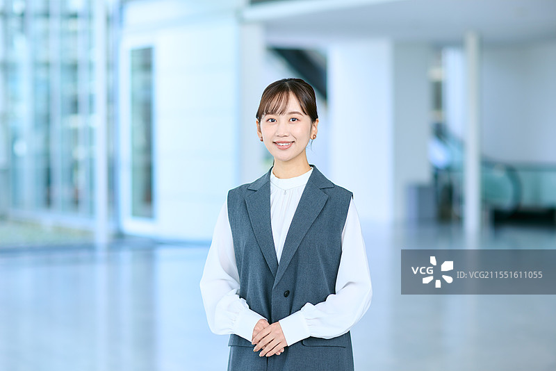 在办公大楼内站着的日本女商人图片素材