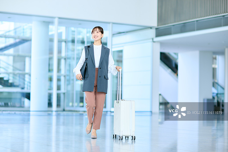 手提行李的日本女性在机场走动图片素材