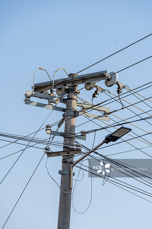 蓝天交错的电线和破旧的电线杆图片素材