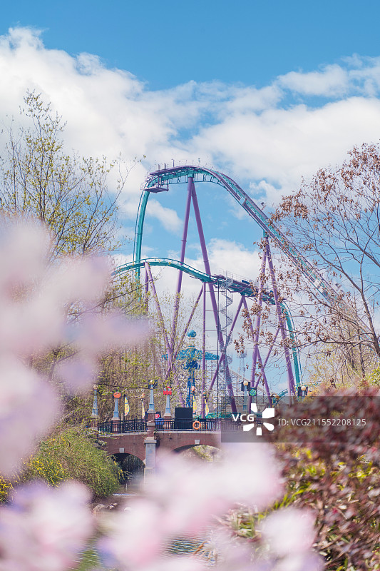 春天阳光下开满鲜花的成都欢乐谷里的过山车图片素材