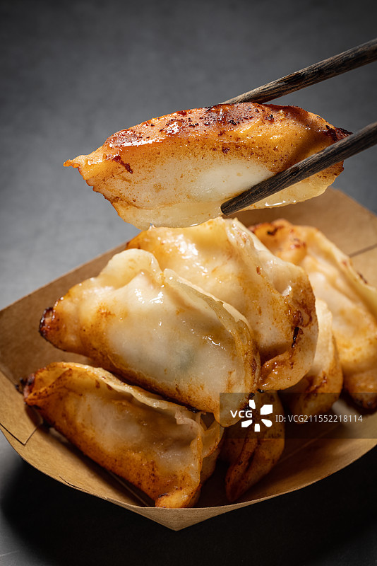 筷子夹起的煎饺图片素材