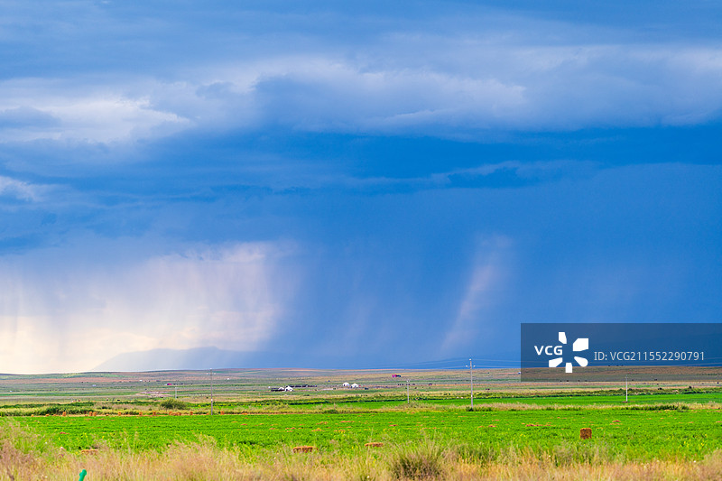 新疆伊犁远处草原倾盆大雨草原气候图片素材