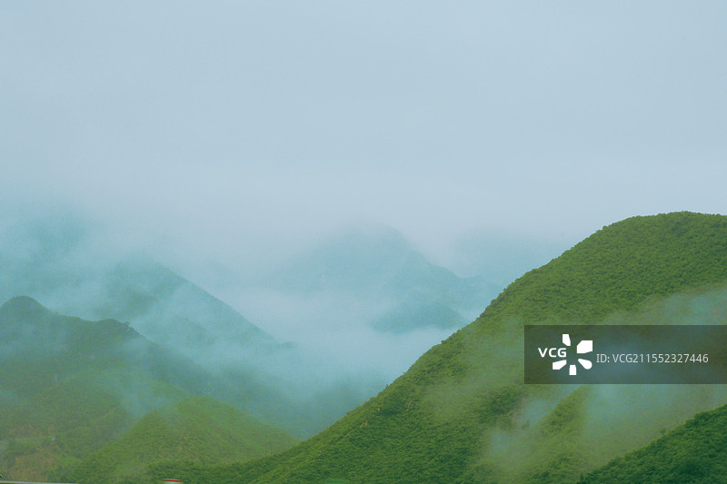 阴雨天。被云雾环抱的青山。烟雨蒙蒙。云雾缭绕。朦胧似仙境图片素材