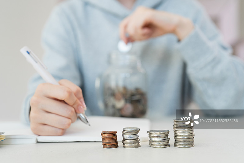 独自生活的成年女性，单身，储蓄，银行，存折，储蓄罐，硬币，硬币捆。图片素材