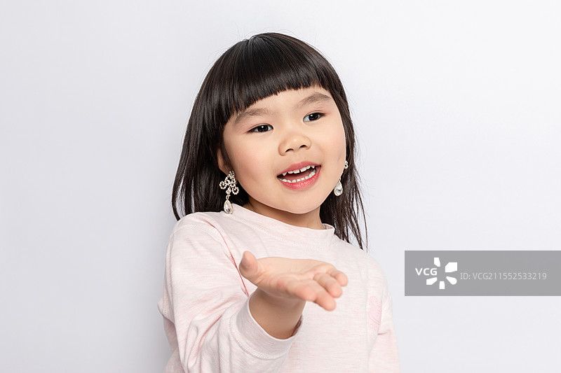 白色背景中一个模仿大人妆容的小女孩图片素材