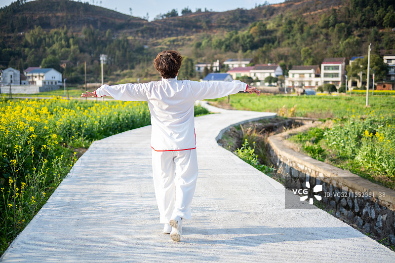 春天乡村小路上散步晨练的老年人背影图片素材